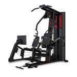 Black multi-station home gym with leg extension/press attachments, cable pulleys, weight stack, and a side monitor for workouts.
