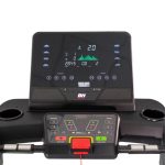 Treadmill console with BH branding, display showing metrics and a red emergency stop button, surrounded by incline and speed controls.
