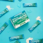 ALLNUTRITION ELECTROLYTES STICK orange flavour box with individual sachets scattered on a blue background